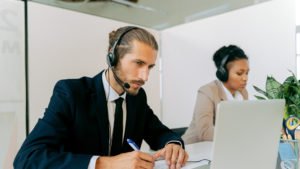 a man wearing a headset and looking at a laptop
