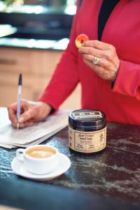 a person sitting at a table with a cup of coffee and a can