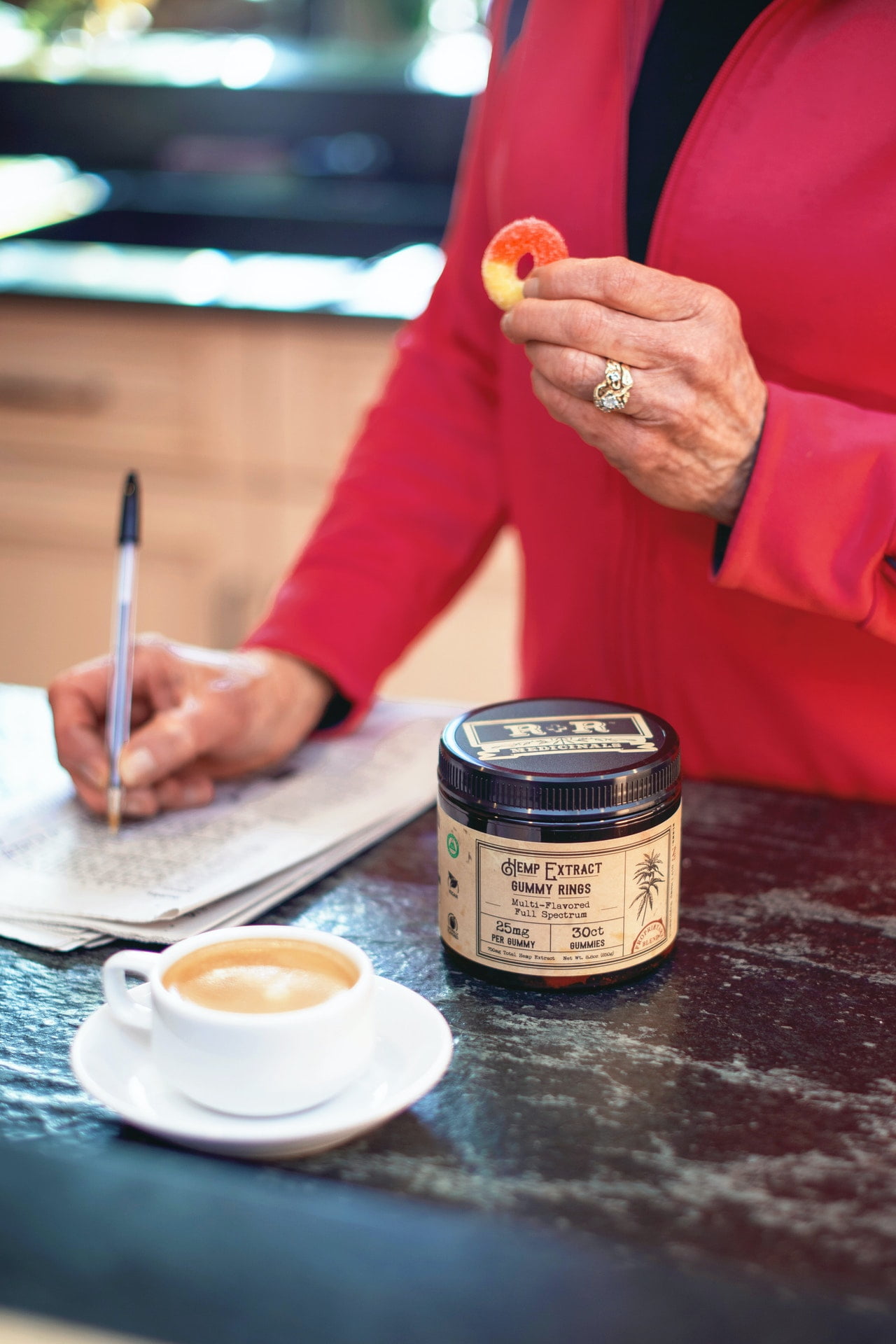 a person sitting at a table with a cup of coffee and a can