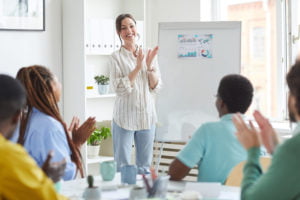 Smiling Female Manager Applauding in Meeting