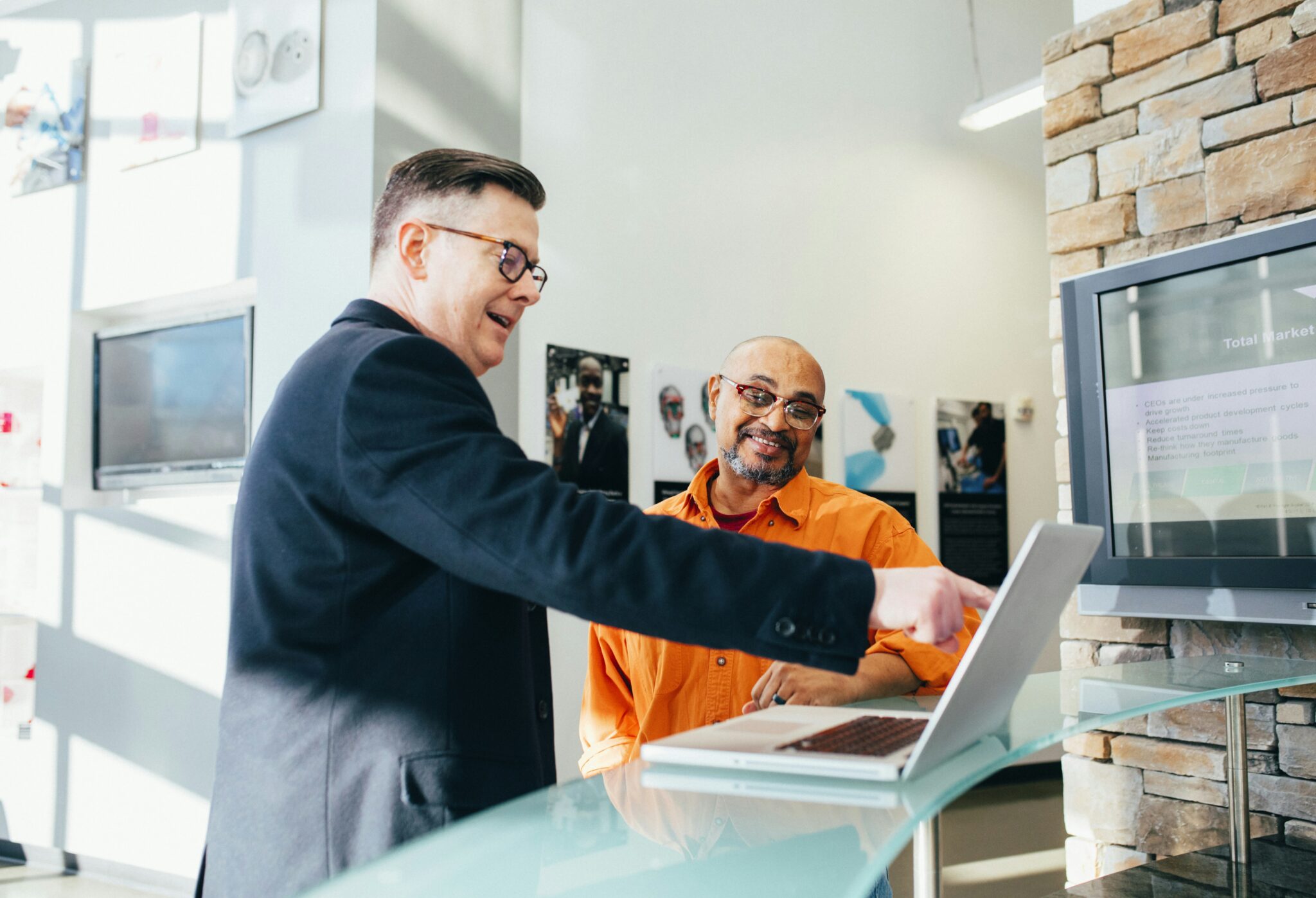 a man showing a man something on the laptop