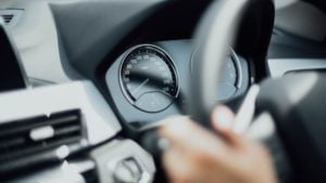 a hand holding a steering wheel