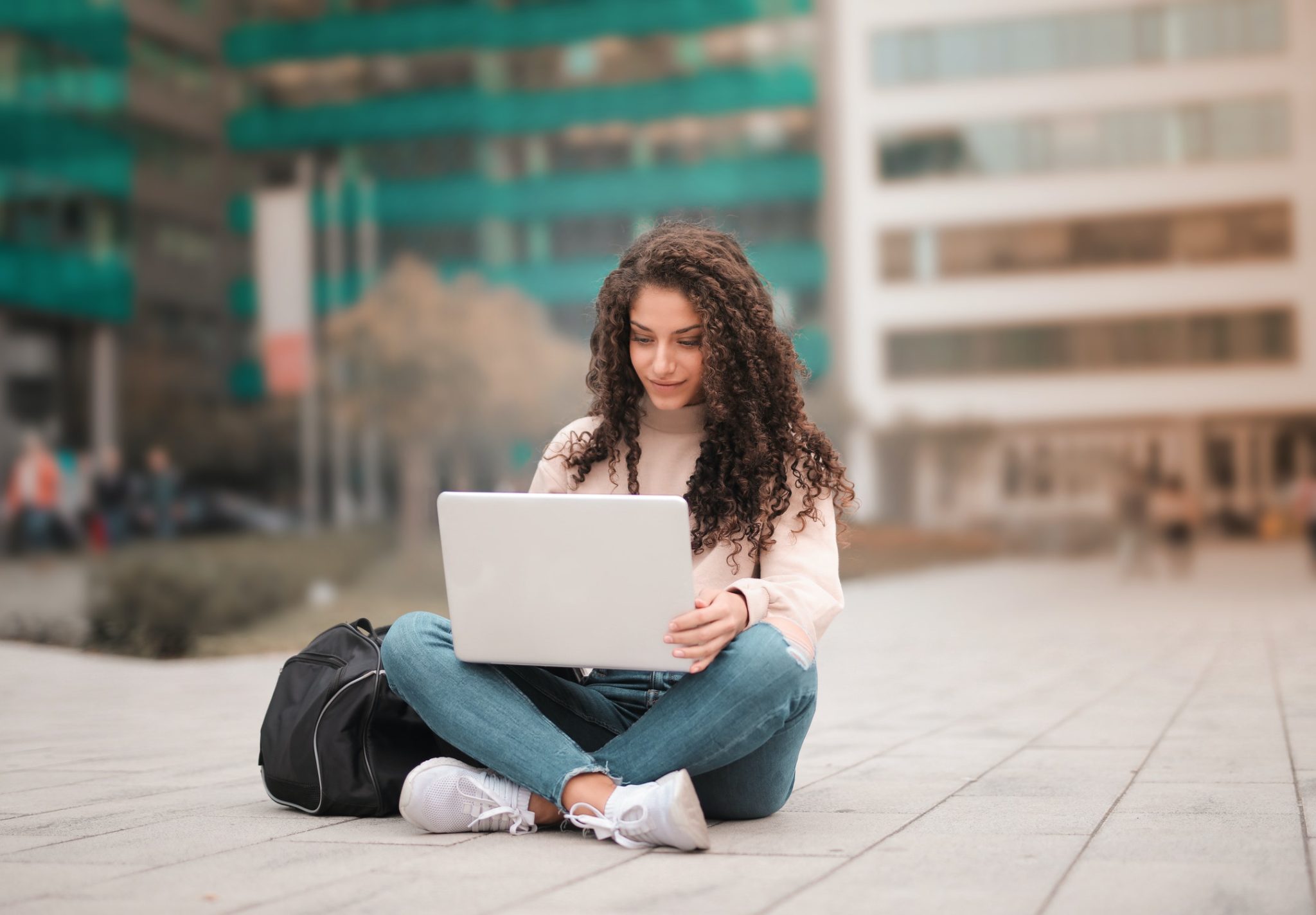 a person sitting on the ground with a laptop